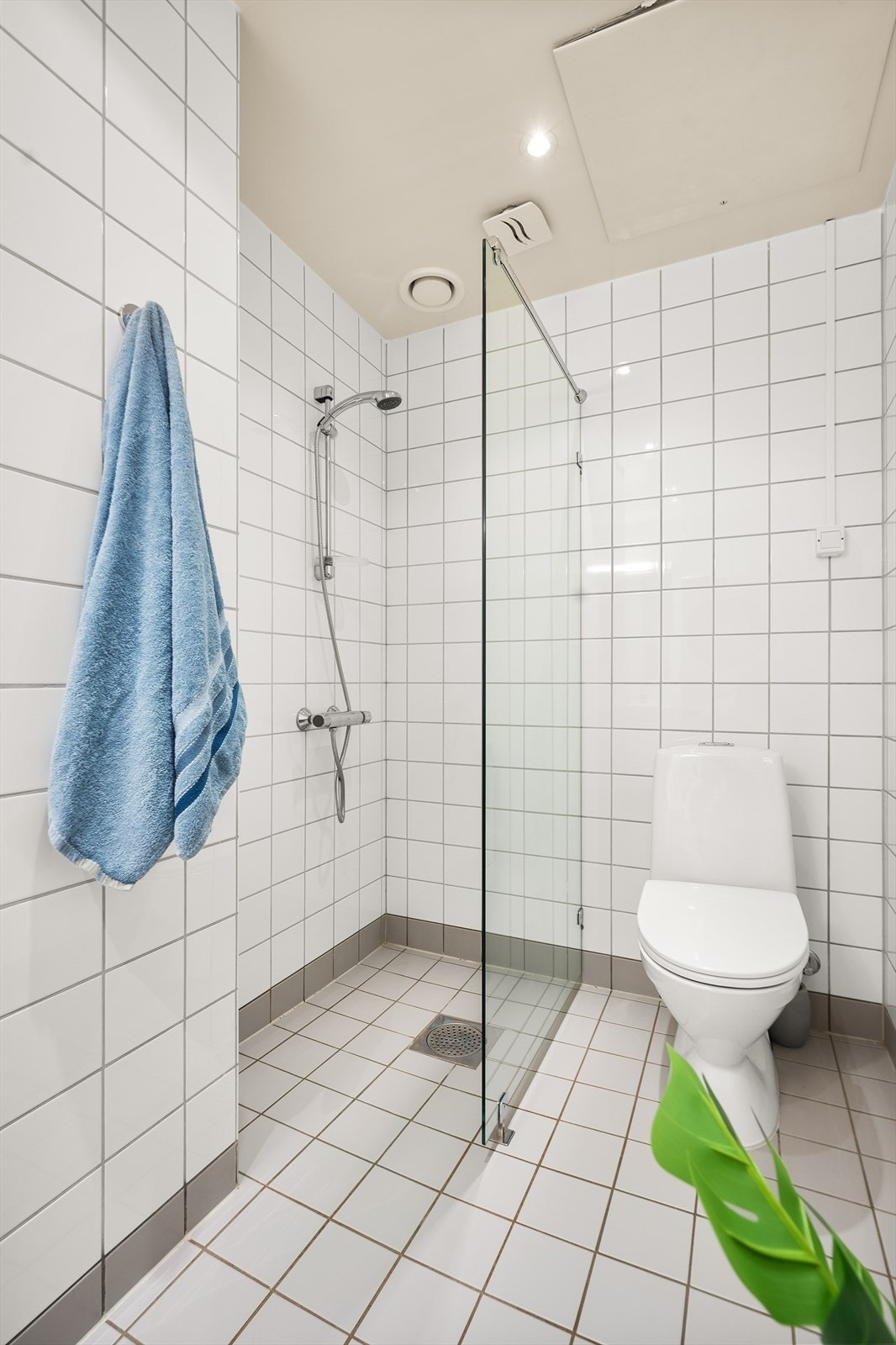 Rommet er innredet med gulvstående toalett, dusjhjørne med glassvegg og baderomsinnredning med hyller, servant nedfelt i innredning og innfelt speil. Opplegg for vaskemaskin. Galleribilde