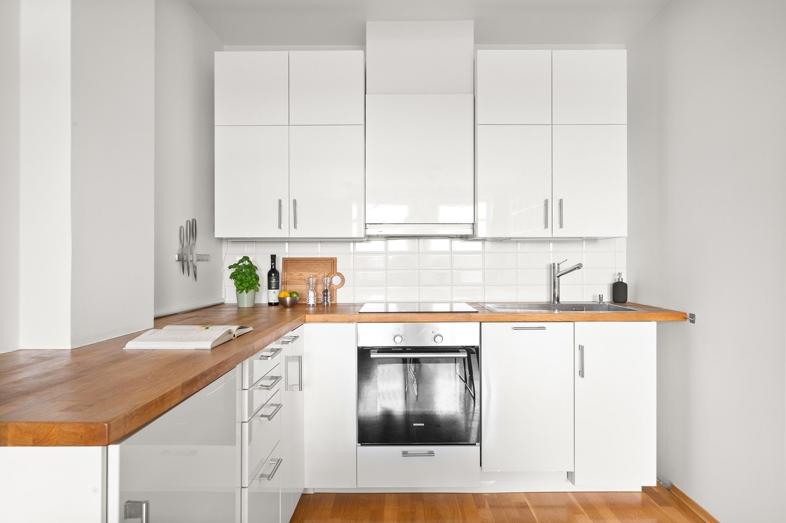 Tidløst og moderne kjøkken. Kjøkkeninnredning med glatte fronter, heltre benkeplate med nedfelt vaskekum. Galleribilde