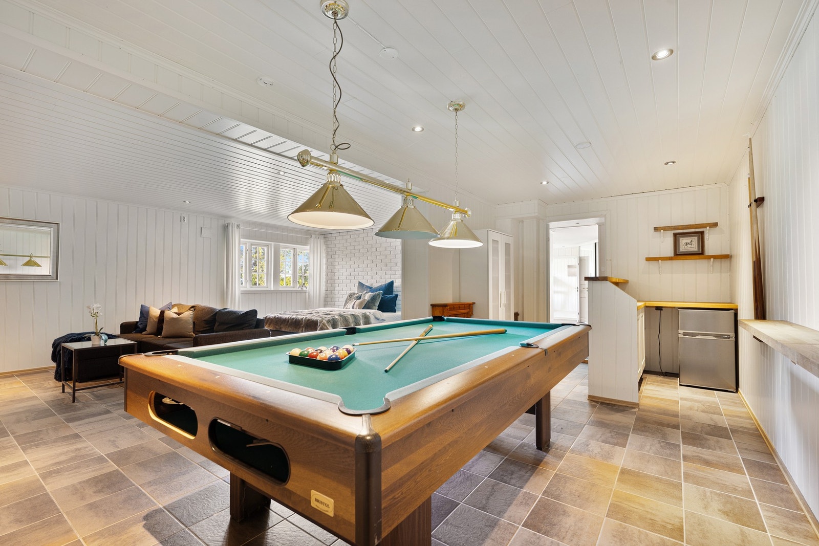 Enten det er tenåringen som ønsker sitt eget sted, eller familien som ønsker en ekstra sone for filmkvelder og gjester - denne kjellerstuen leverer på både komfort og fleksibilitet. Galleribilde