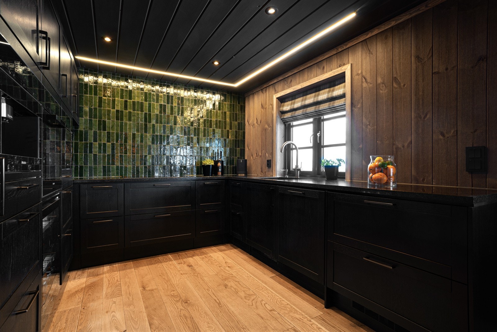 Kjøkkenet er utformet som en hestesko, slik at man kan lage mat og samtidig deltar i samtalene med gjester/familien rundt spisebordet Galleribilde