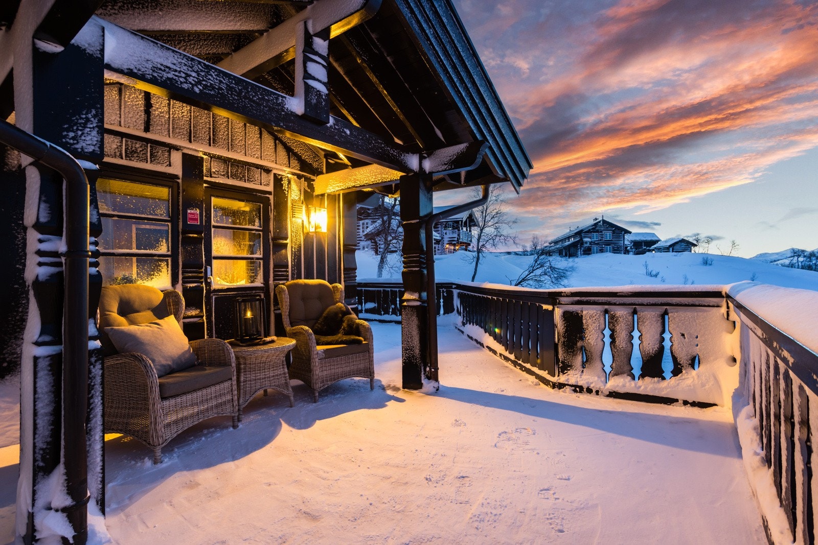 Fra stuen er det utgang til solrik terrasse som strekker seg rundt flere sider av hytta Galleribilde