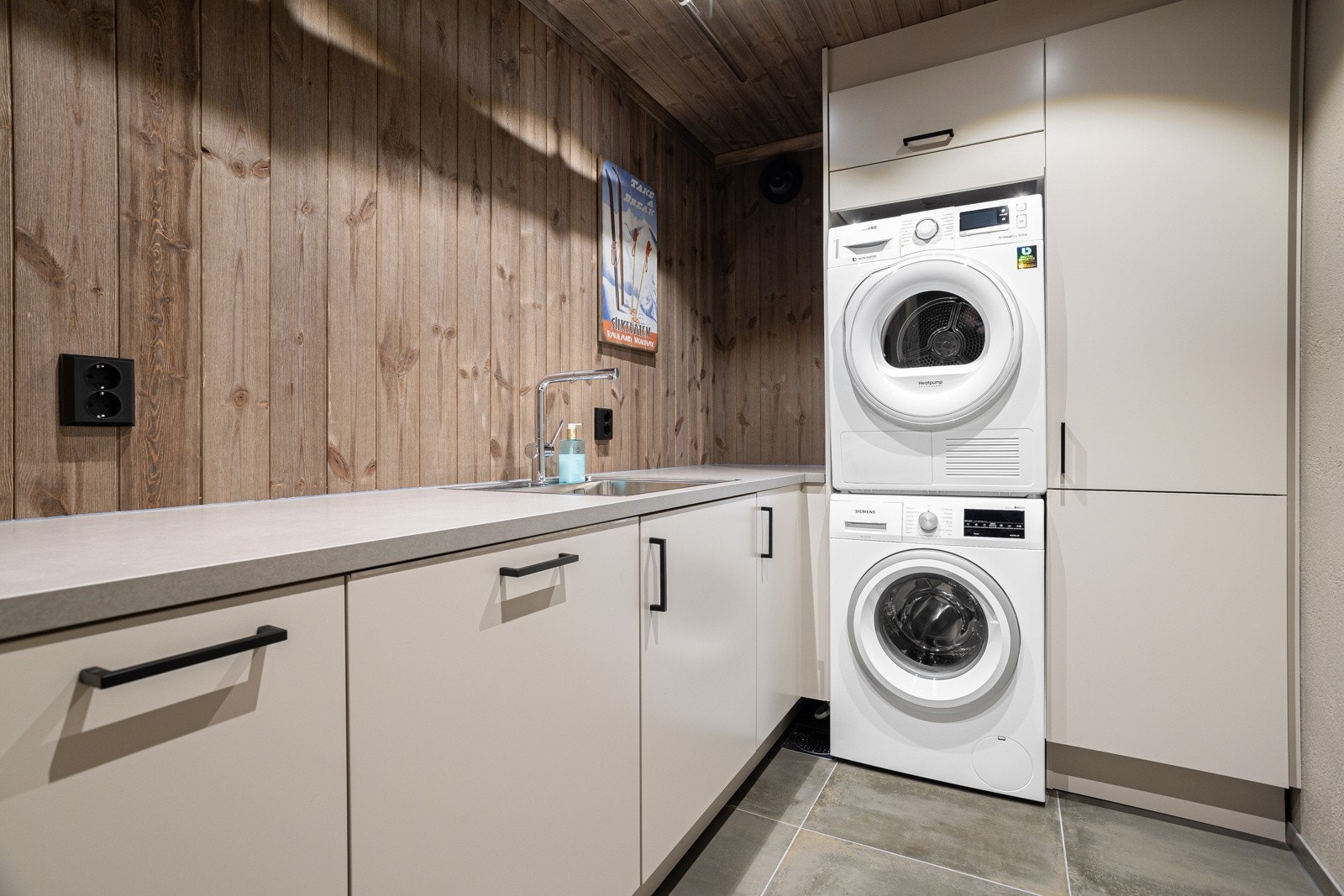 Svært lekkert og praktisk vaskerom med innredning fra Norema. Rommet har oppvaskmaskin, vaskemaskin og tørketrommel Galleribilde