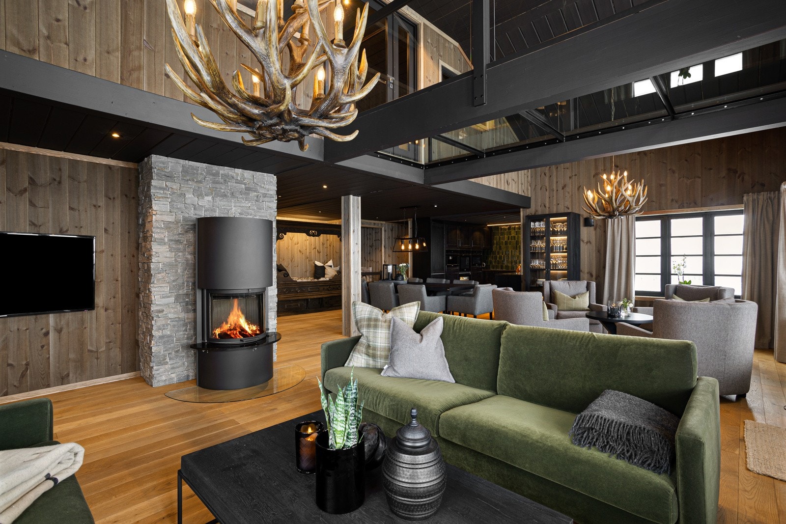 Sentrert i rommet utsmykker det seg en moderne peis som setter stemningen i rommet Galleribilde