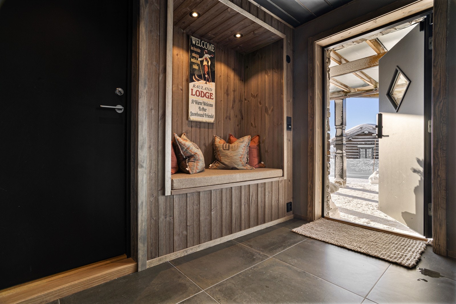 Man ankommer hytta via et praktisk, overbygget inngangsparti. Videre kommer man inn i en meget innbydende hall med garderobeskap og plassbygget sittebenk Galleribilde