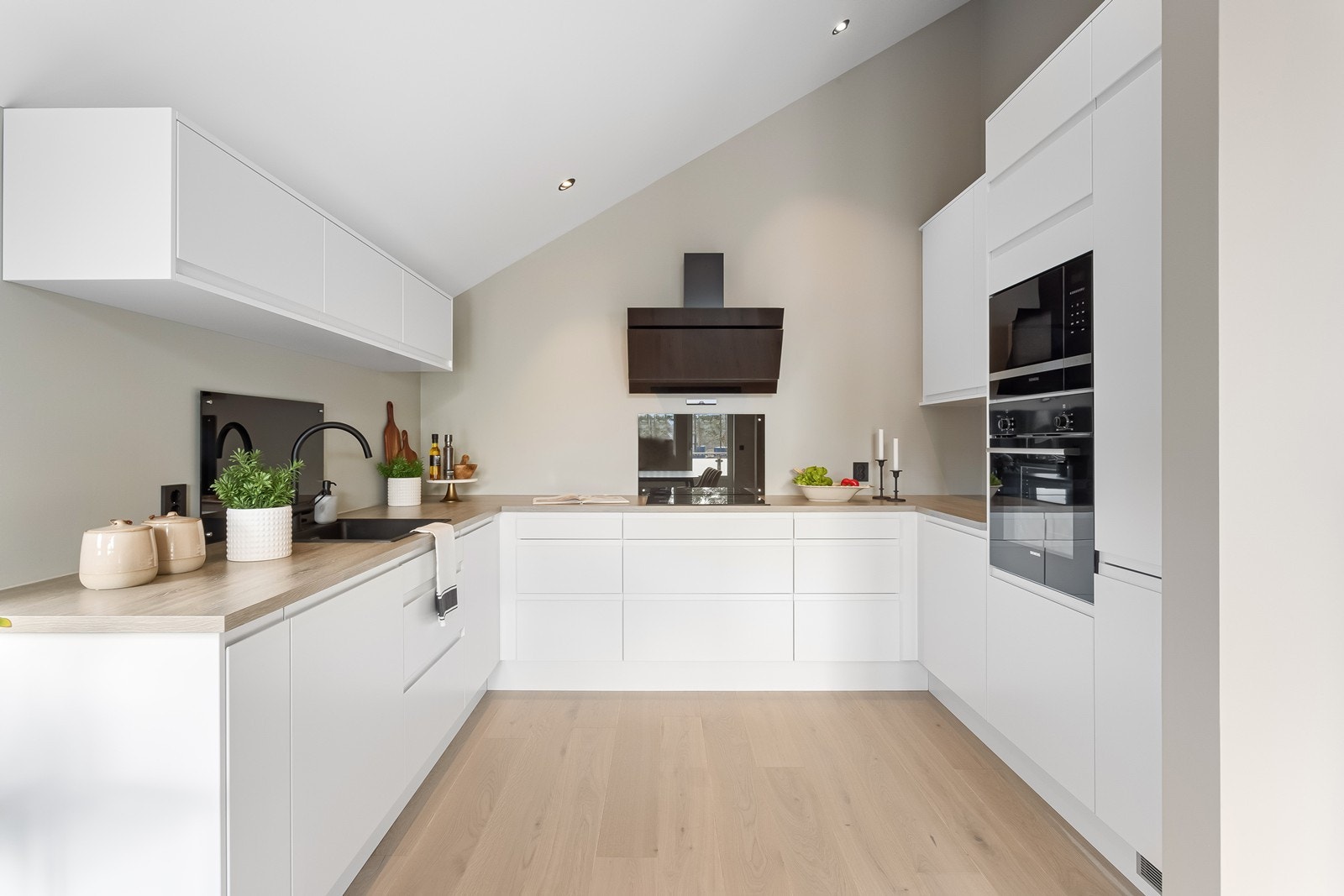 Det stilrene kjøkkenet har lys kjøkkeninnredning fra Norema og benkeplate i laminat. Galleribilde