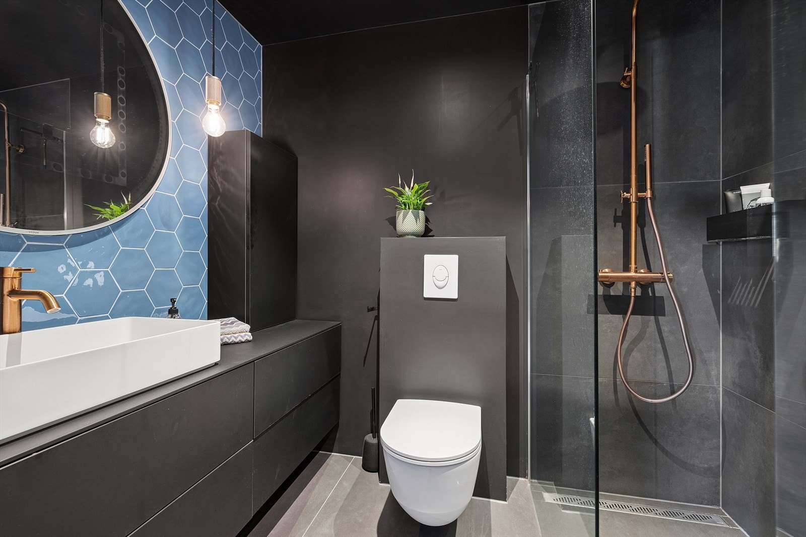 Meget lekkert baderom med servant i innredning med skuffer, vegghengt wc og dusjhjørne med glassvegg Galleribilde