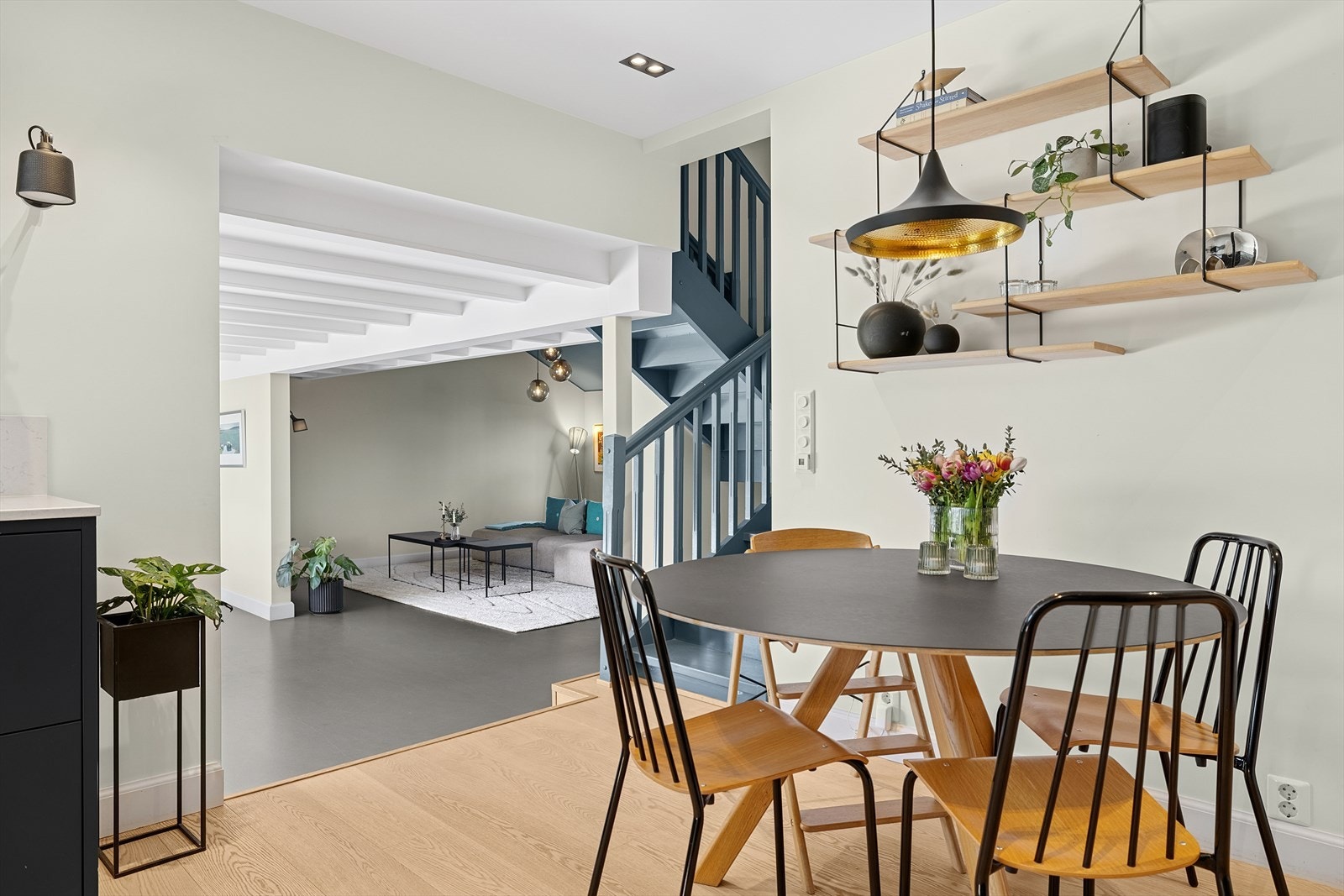 Fra kjøkkenet er det stor åpning liten trappeavsats til boligens spisestue og stue Galleribilde