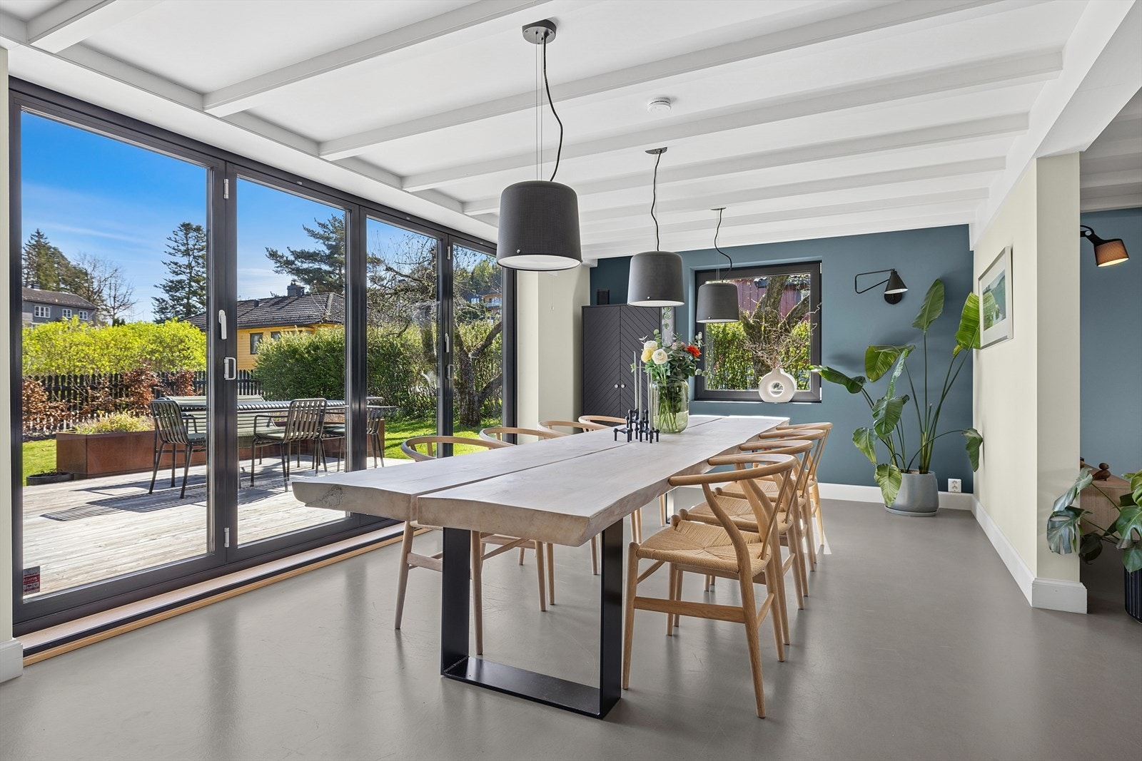 Stilrent stue med store lysflater og foldedører til terrasse Galleribilde