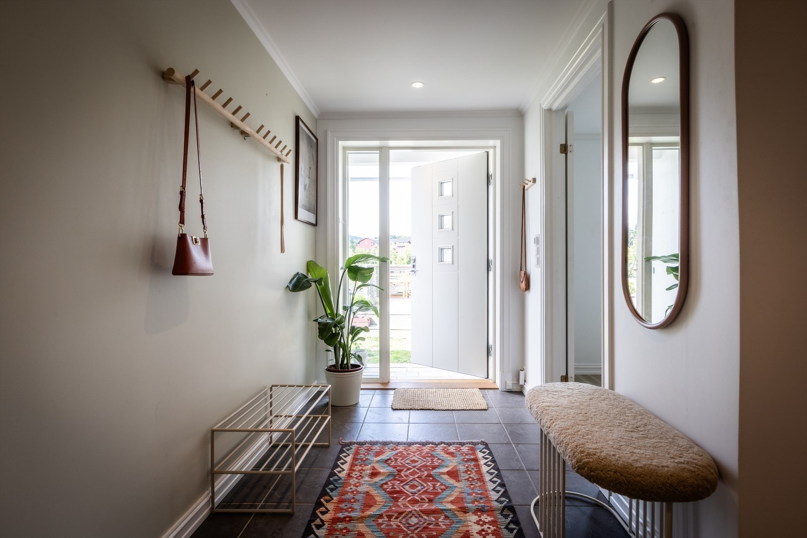 Entréen fremstår som lys og innbydende, med flislagt gulv med gulvvarme. Overflatene består av malte vegger og malt himling med downlights som gir god belysning. Galleribilde