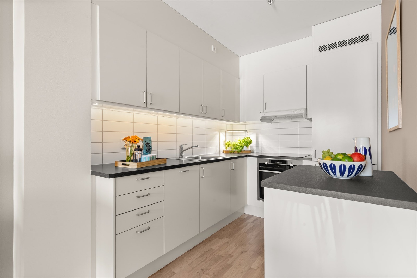 Innredningen består av slette, lyse fronter og benkeplate av laminat med lyse fliser. Galleribilde