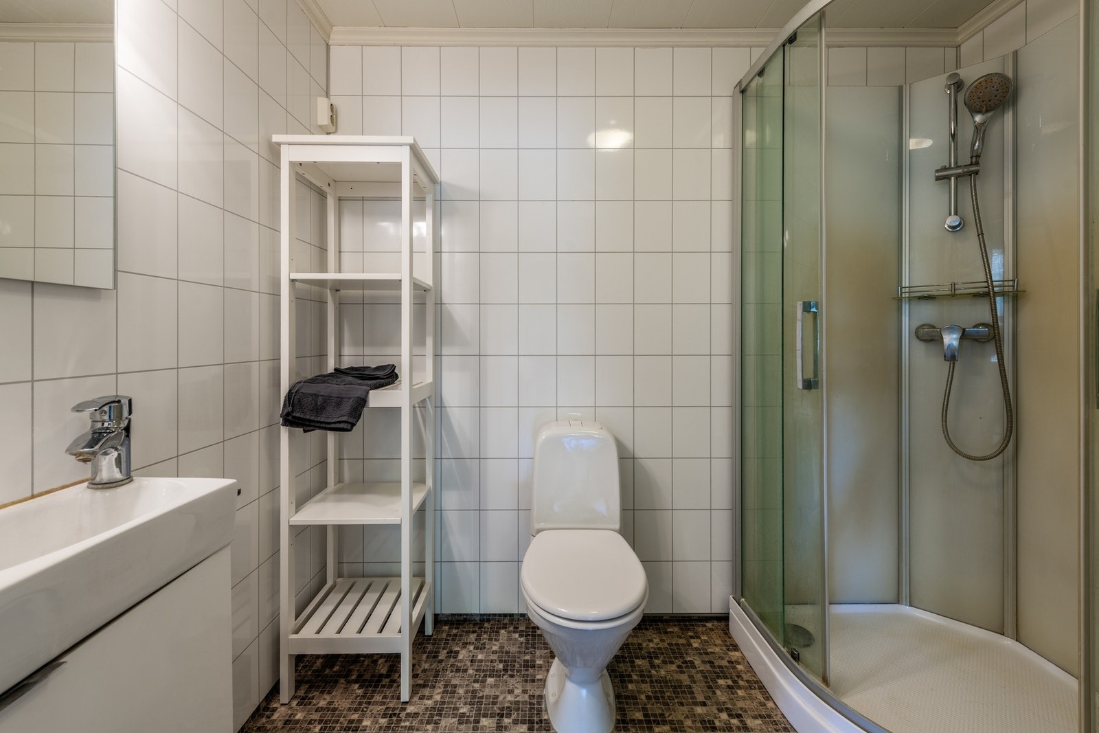 Funksjonelt bad med flislagte vegger og dusjkabinett Galleribilde