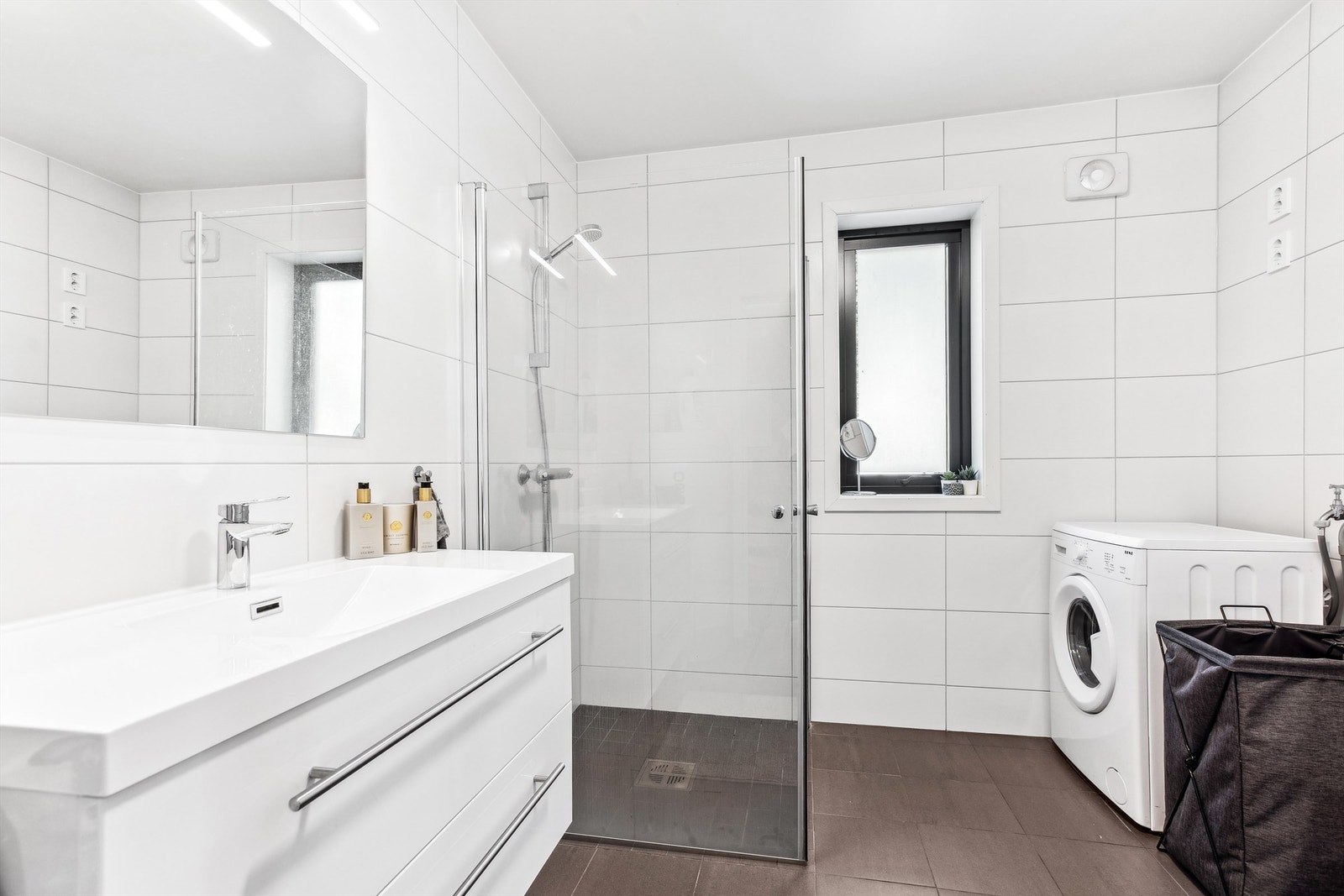 Badet i utleiedelen har grå gulvfliser, hvite veggfliser, gulvvarme, avtrekksvifte og opplegg for vaskemaskin. Innredningen består av en heldekkende servant med hvite underskuffer, og over servanten er det speil med belysning. I tillegg har badet toalett. Galleribilde