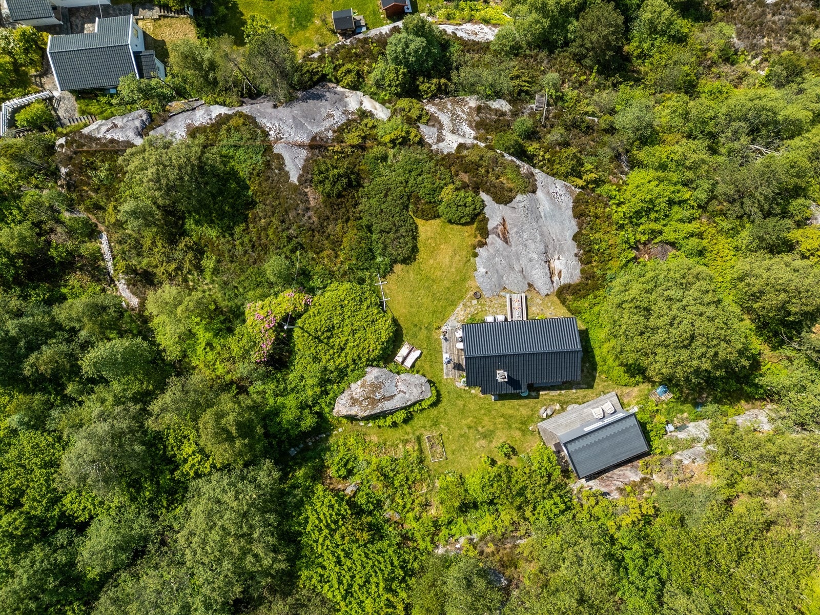 Eiendommen har en pent opparbeidet og beplantet hage. Det er gangsti og trapper som leder ned fra parkeringsområdet, og parkering skjer på egen eiendom. Galleribilde