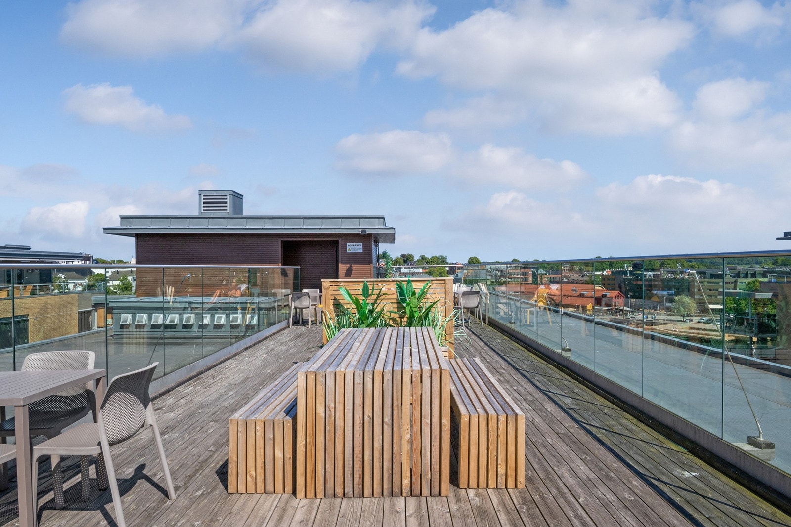 Sommerdagene tilbringes også på en flott takterrasse i bygget, med sittegrupper, glassrekkverk og fantastisk utsikt. Galleribilde