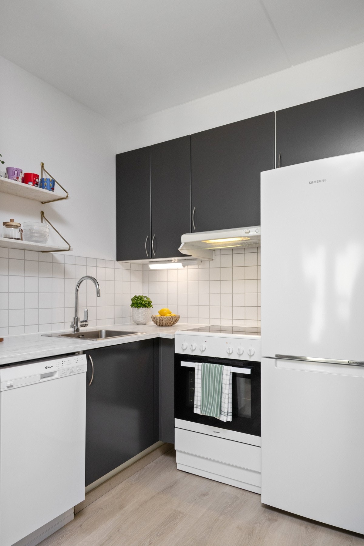 Entreen glir sømløst over i et praktisk kjøkken, oppført i en liten L-form i direkte tilknytning til stuen. Galleribilde