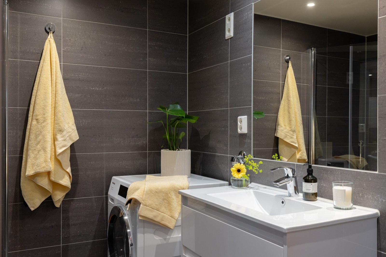 På badet er det dusjhjørne, lys innredning, vegghengt toalett og opplegg for vaskemaskin og tørketrommel. Galleribilde