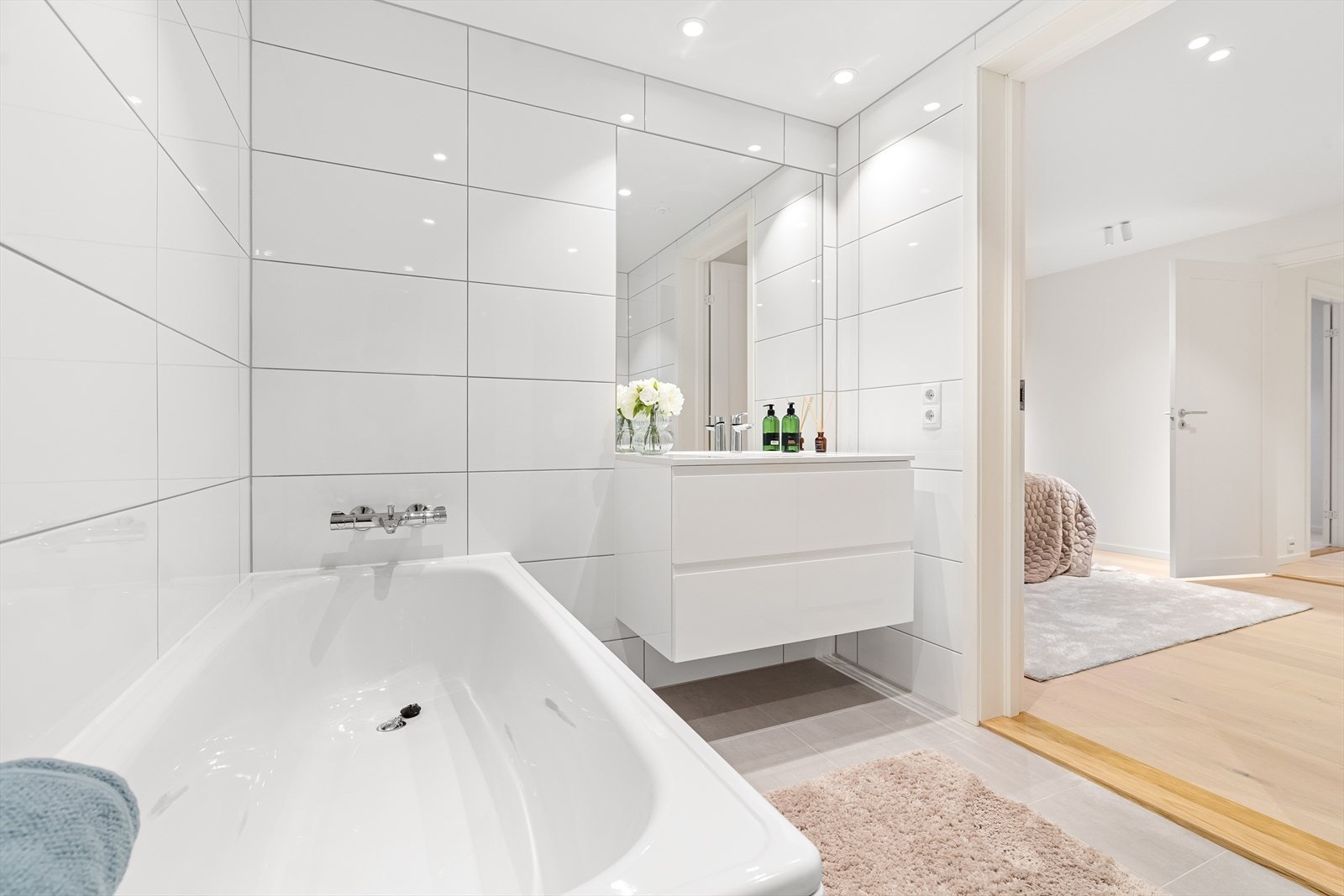 Baderommene har servantskap med glatte fronter, overlimt servant med ettgreps armatur fra Grohe, innfelt speil på vegg, videre er de utstyrt med dusjnisje med innfellbare glassdører. Galleribilde