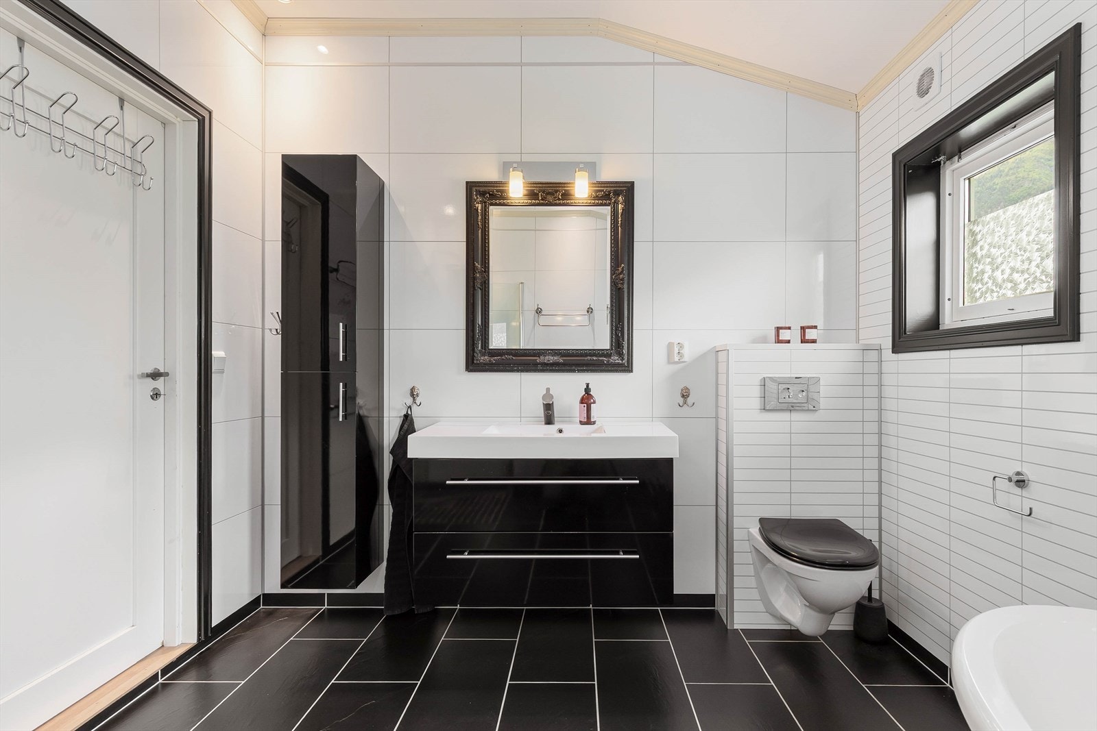 Rommet har innredning med nedfelt
servant, veggmontert toalett, badekar og dusjvegger/hjørne. Galleribilde