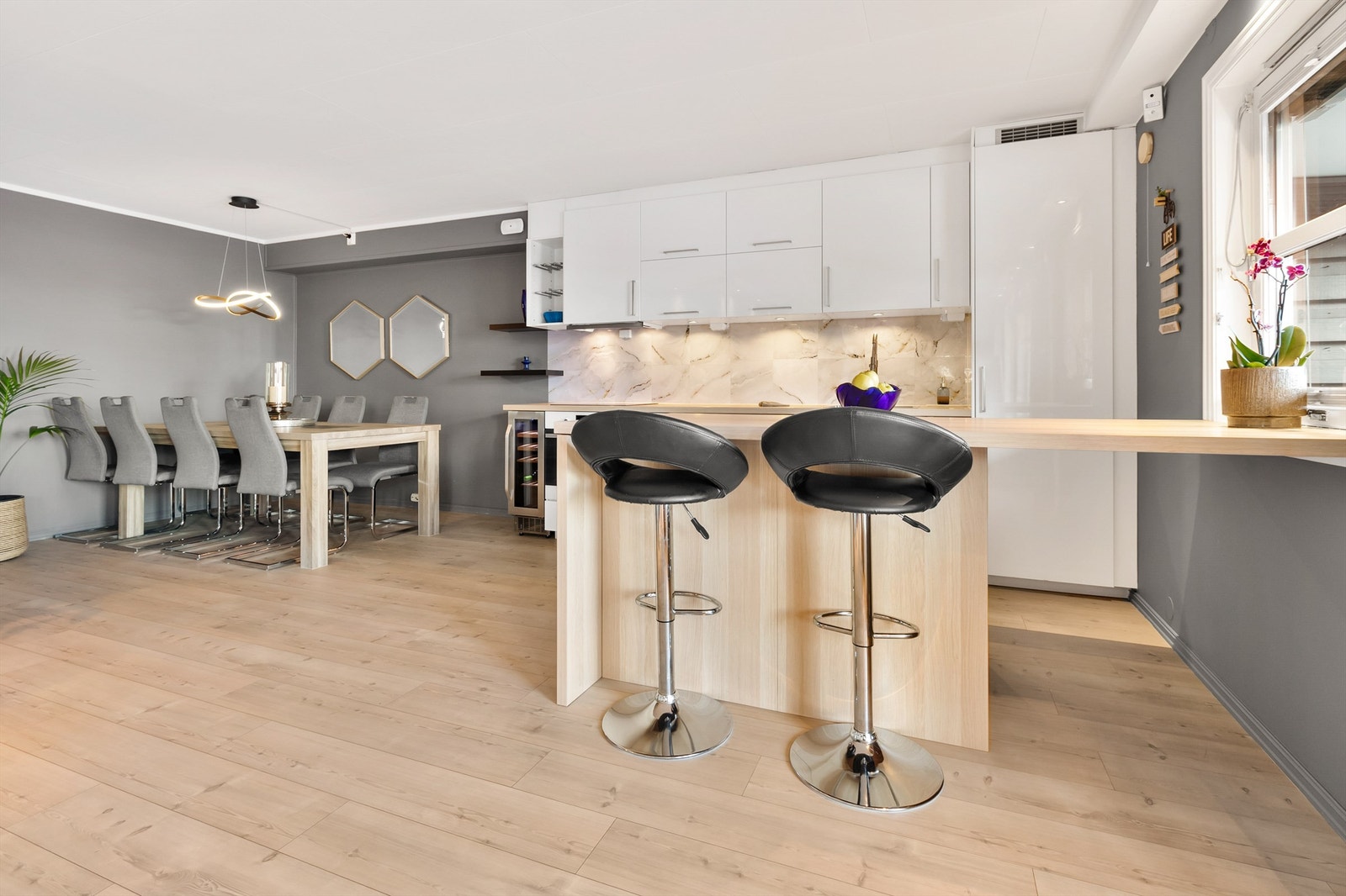 Stuen er åpen og innbydende med flytene overgang mellom spisestue, sofasone og kjøkken Galleribilde