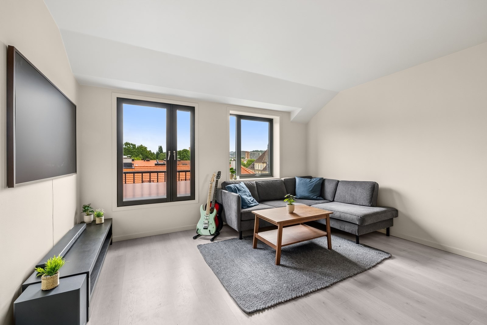 Luftig stue med god plass til sofa med naturlig avstand til tv-seksjon. Galleribilde