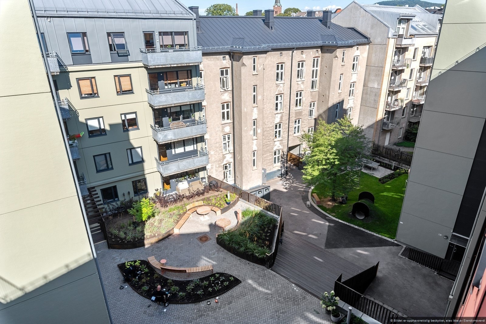 Skjermet og pent opparbeidet bakgård med hyggelige sitteplasser og grøntarealer. Perfekt for rolige stunder midt i byen. Galleribilde