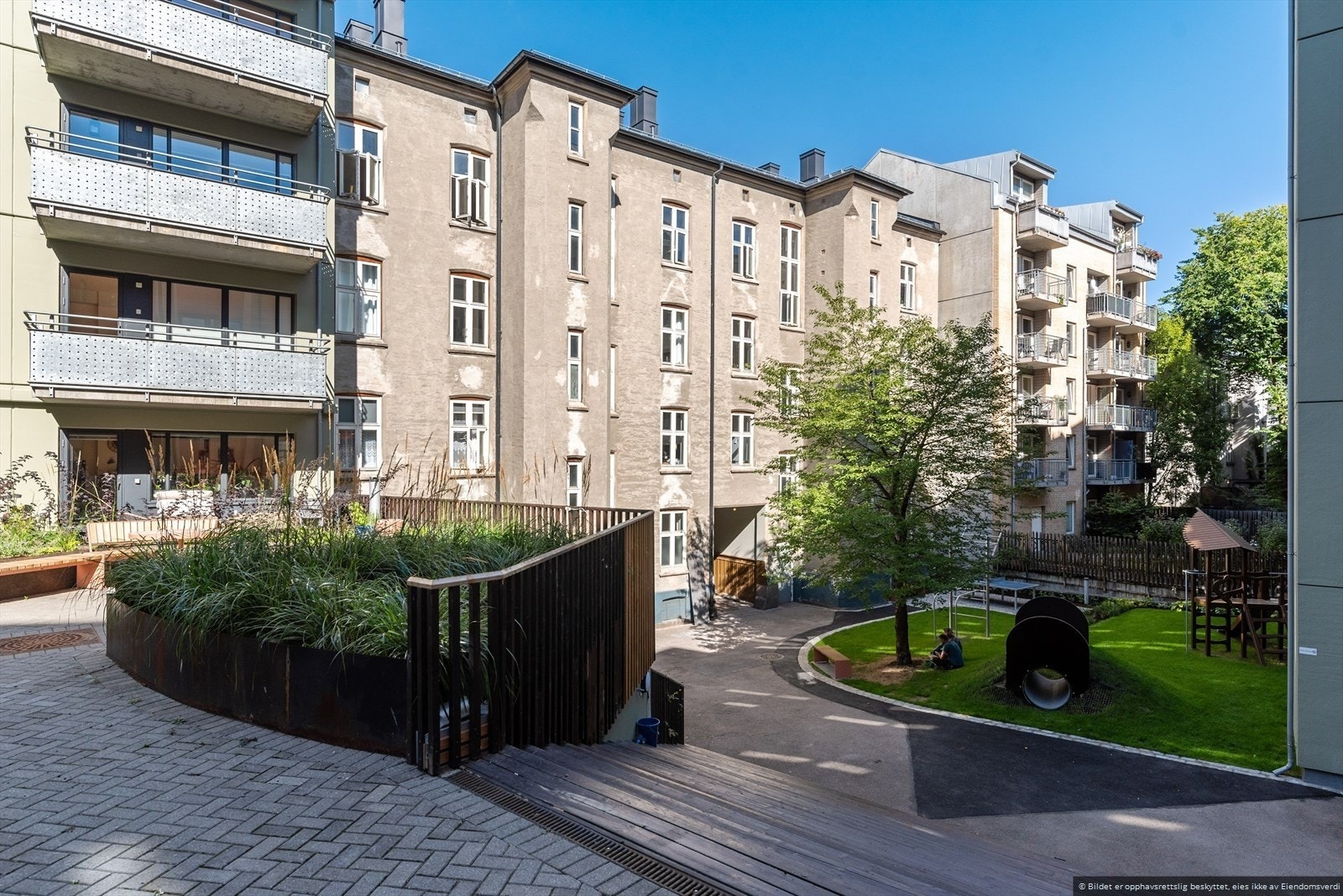 Innbydende bakgård med grøntarealer, lekeplass og fine oppholdsplasser. Et rolig pusterom midt i byen. Galleribilde