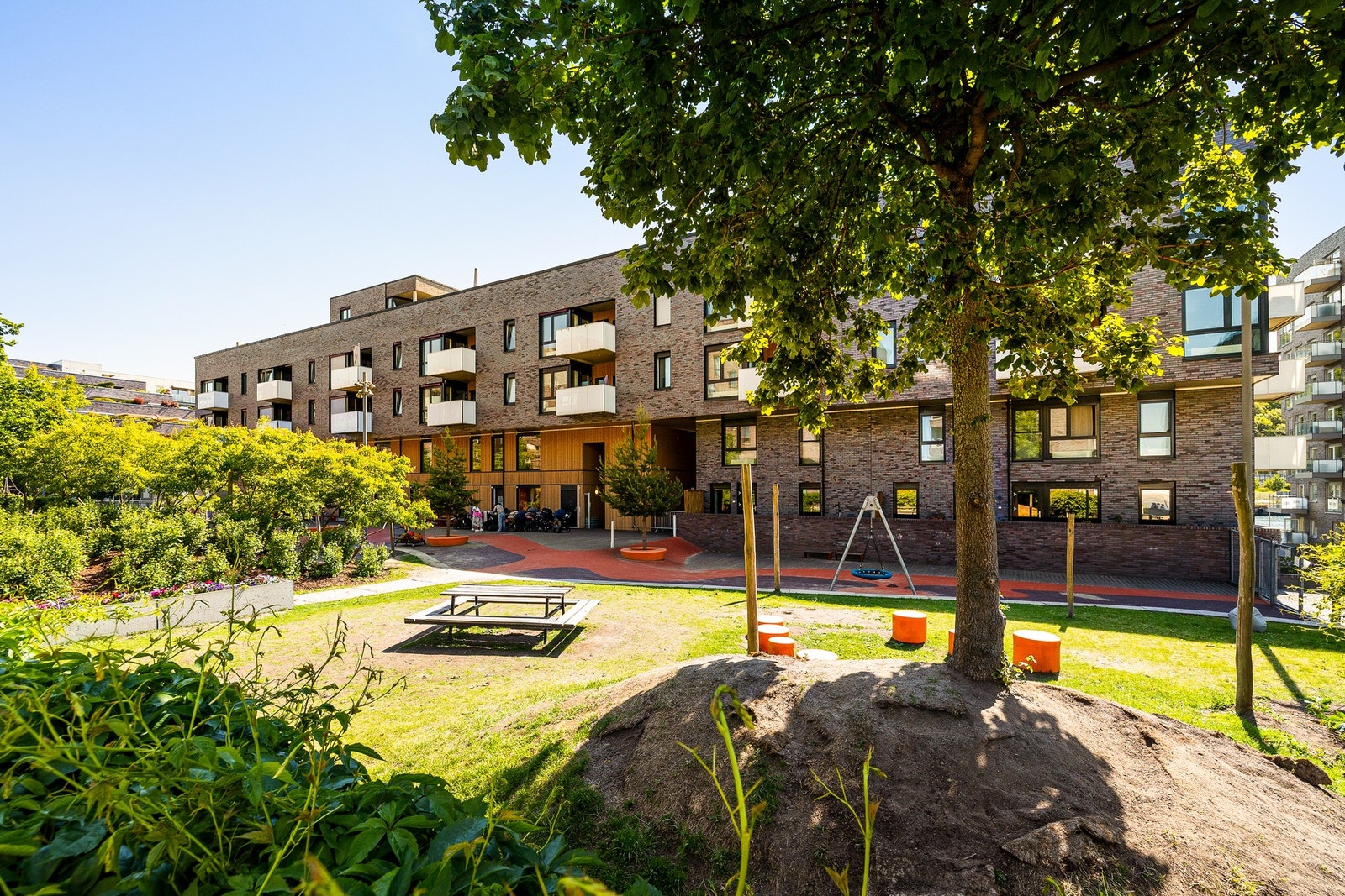 Frodig og skjermet bakgård med benker, lekeapparater og fine møteplasser. Galleribilde