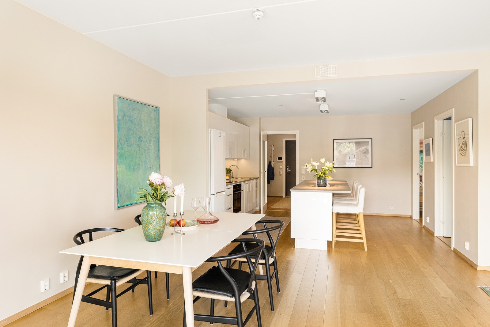 Lekkert kjøkken i åpen løsning med kjøkkenøy og naturlig overgang til spiseplass og stue. Galleribilde