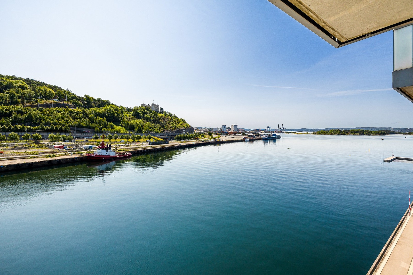 Rolige omgivelser med glitrende sjø og grønne høyder i blikket. Galleribilde