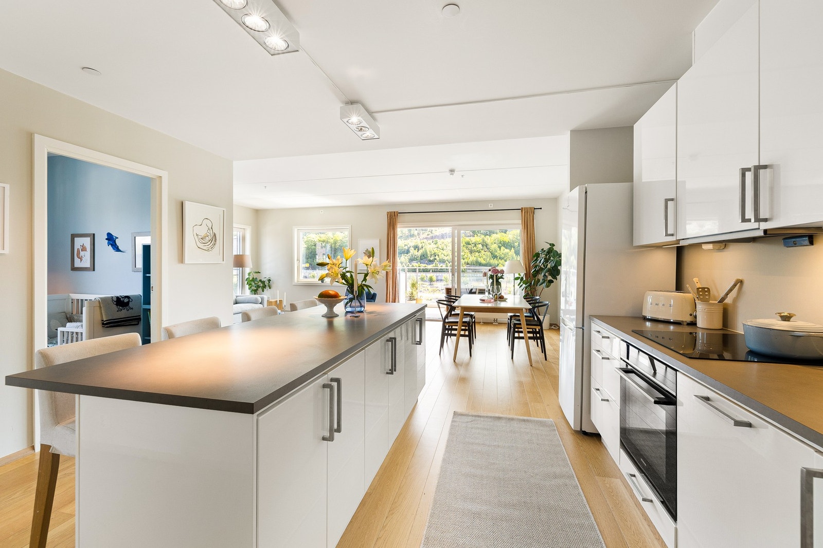 Drømmekjøkken for den sosiale livsnyteren - åpen løsning, kjøkkenøy og nydelig lysinnslipp hele dagen. Galleribilde