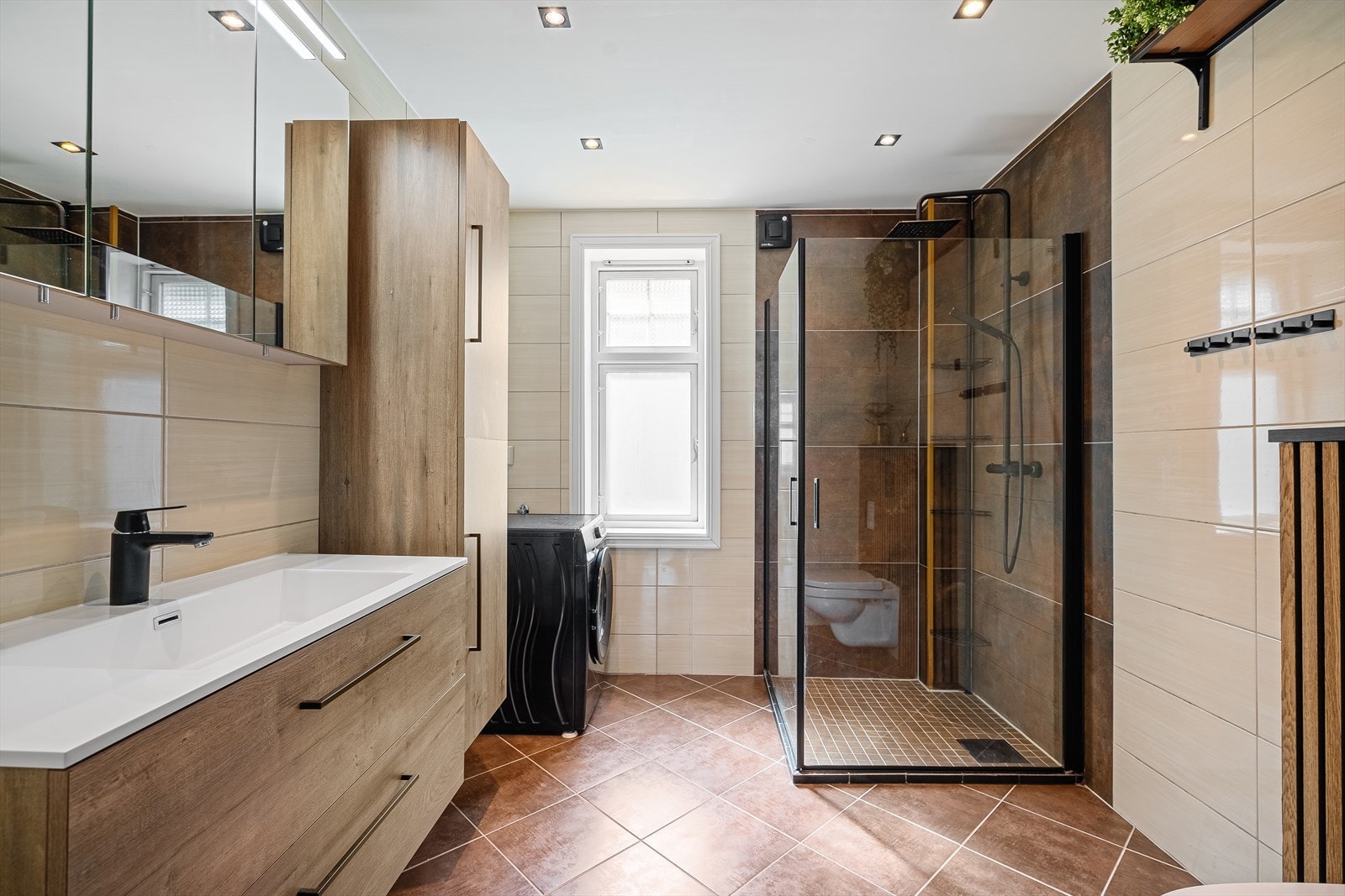 Badet har delikate farger og gode løsninger. Det er innredet med dusjnisje, vegghengt toalett og servant med skapplass. Galleribilde