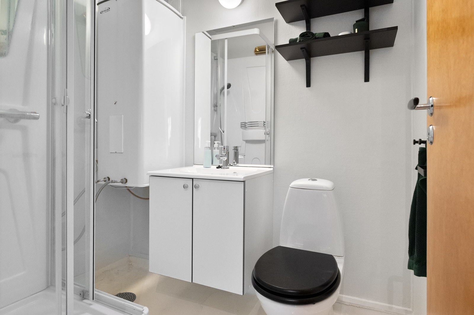 -Bad innredet med toalett, dusjkabinett og vegghengt servant med skapinnredning - Galleribilde