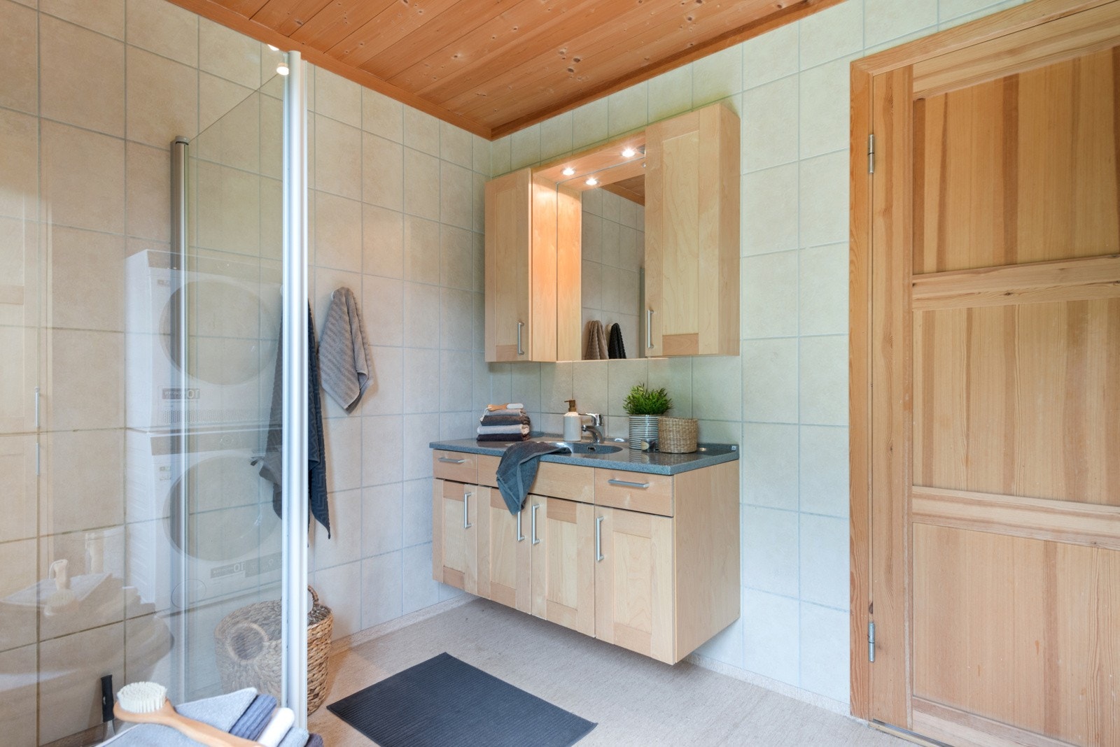 Badet er innredet med toalett, dusjhjørne og servantinnredning med overskap. Galleribilde