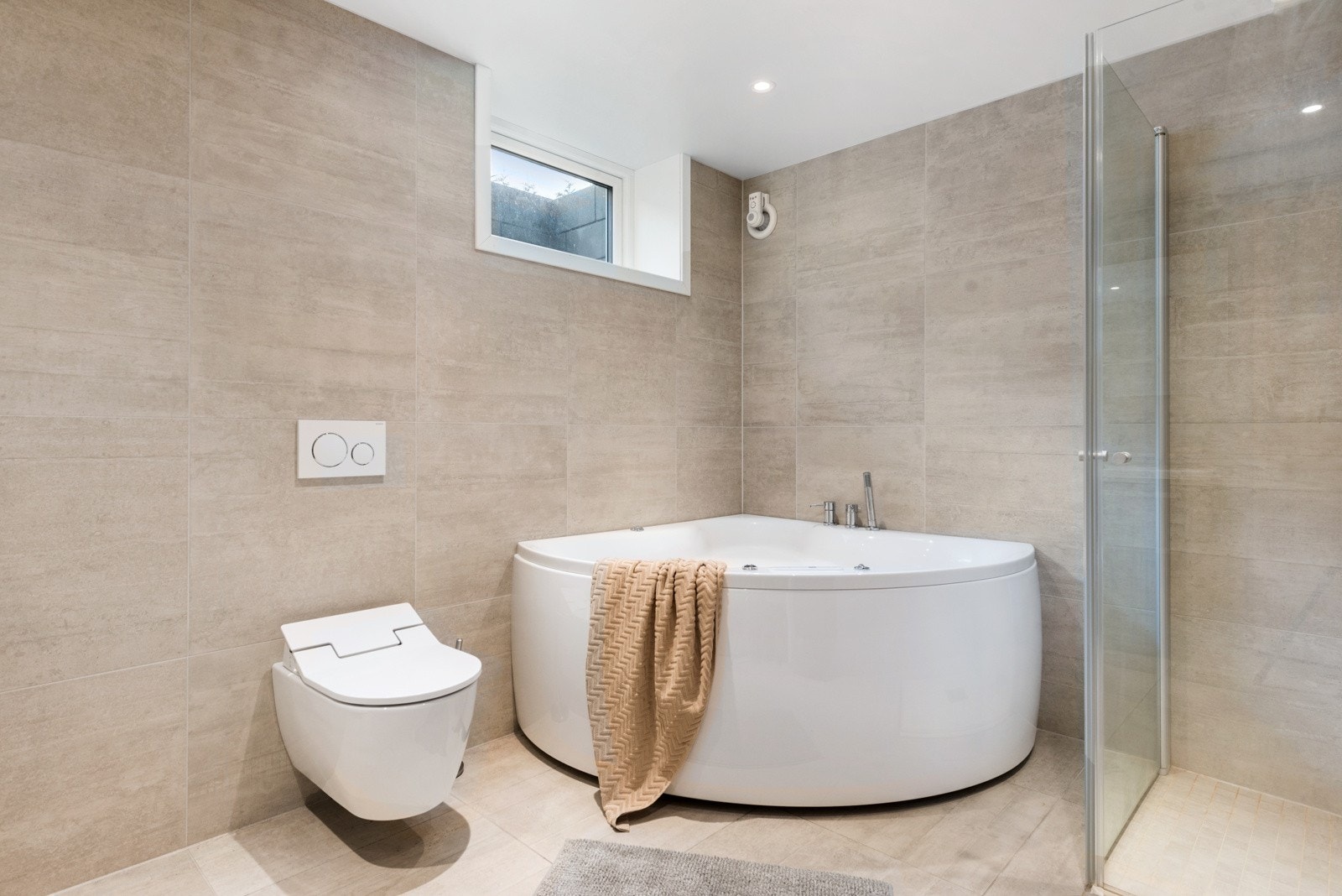 Badet har fliser på vegger og gulv med malte glatte flater i himlingen. Galleribilde