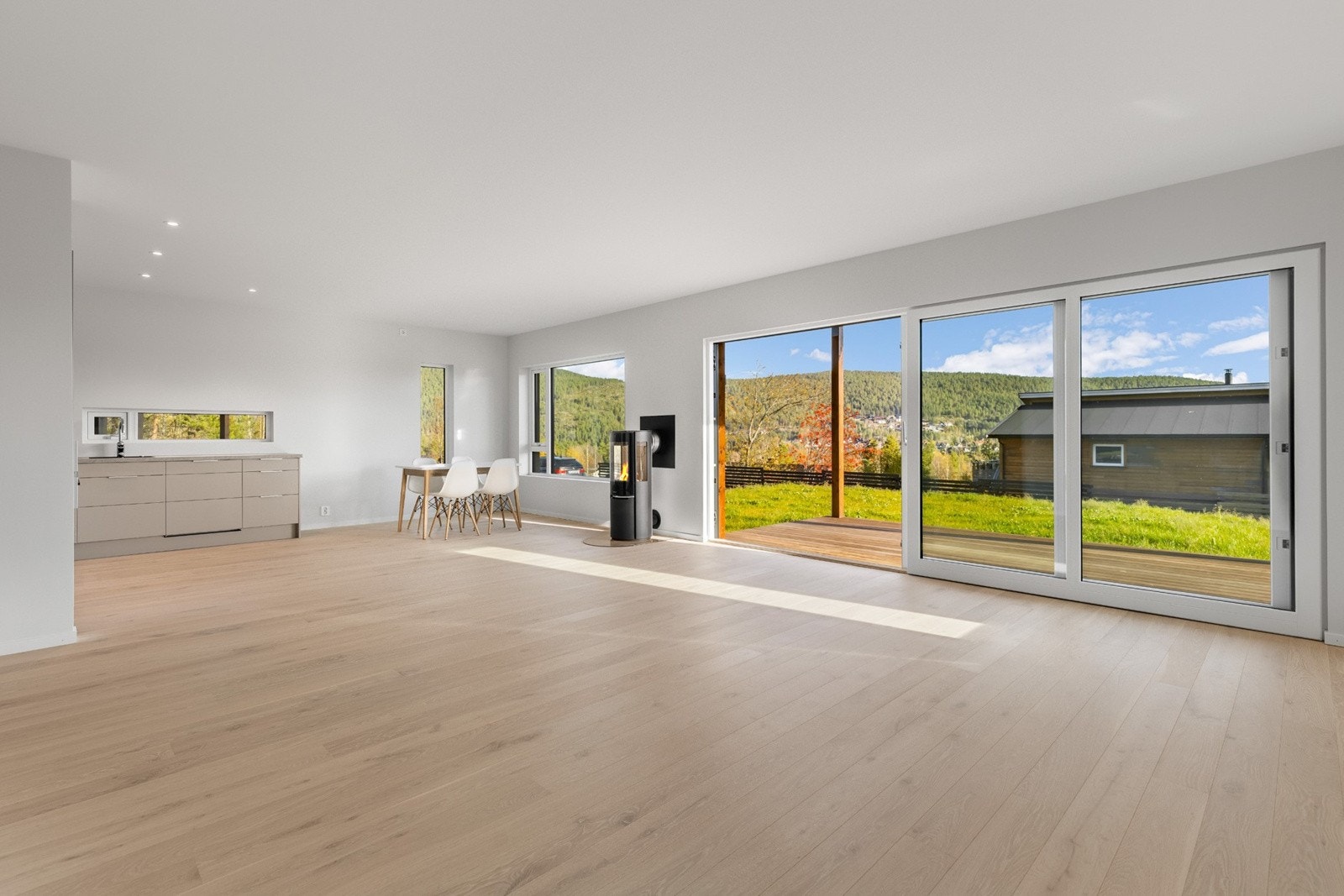 Et spisebord får naturlig plass i grensen mellom stuen og kjøkkenet, mens det er nok av plass til å ha en tv og sofagruppe på motsatt side av rommet. Galleribilde