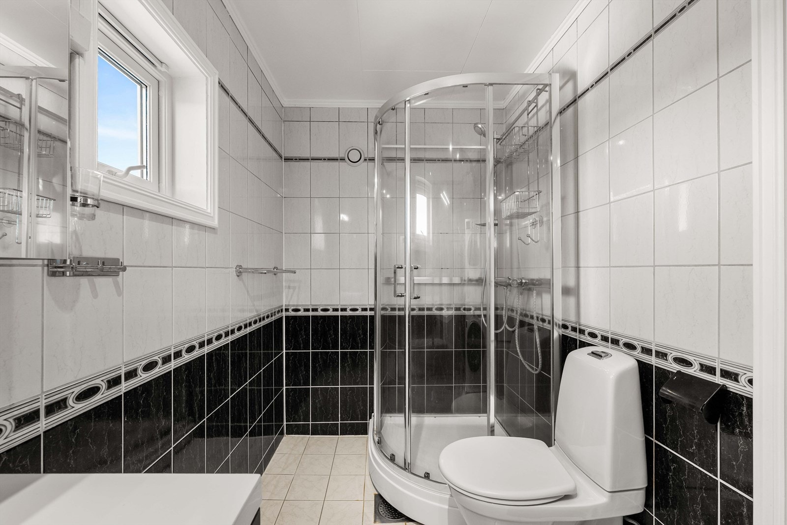 Badet har tidløse flislagte overflater og varme i gulvet. Galleribilde