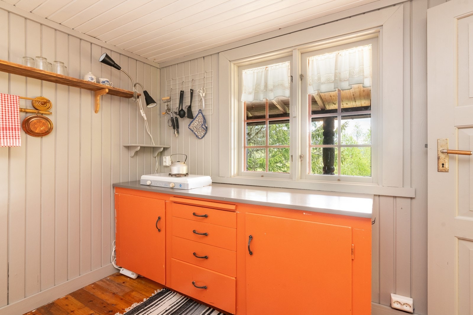 Kjøkkenet har en enkel innredning med slette fronter og benkeplate i malt tre. Galleribilde