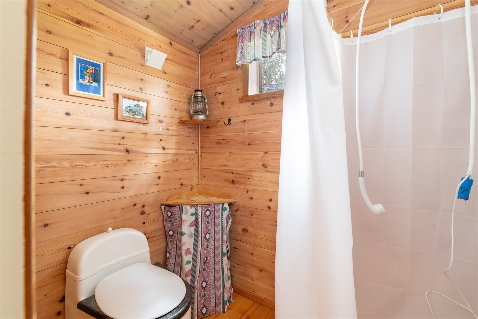 Videre ble det bygget en vedbod i tilknytning til overbygget del av veranda i 2000. Her er det snurredo med fire kammer og pumpedusj. Galleribilde