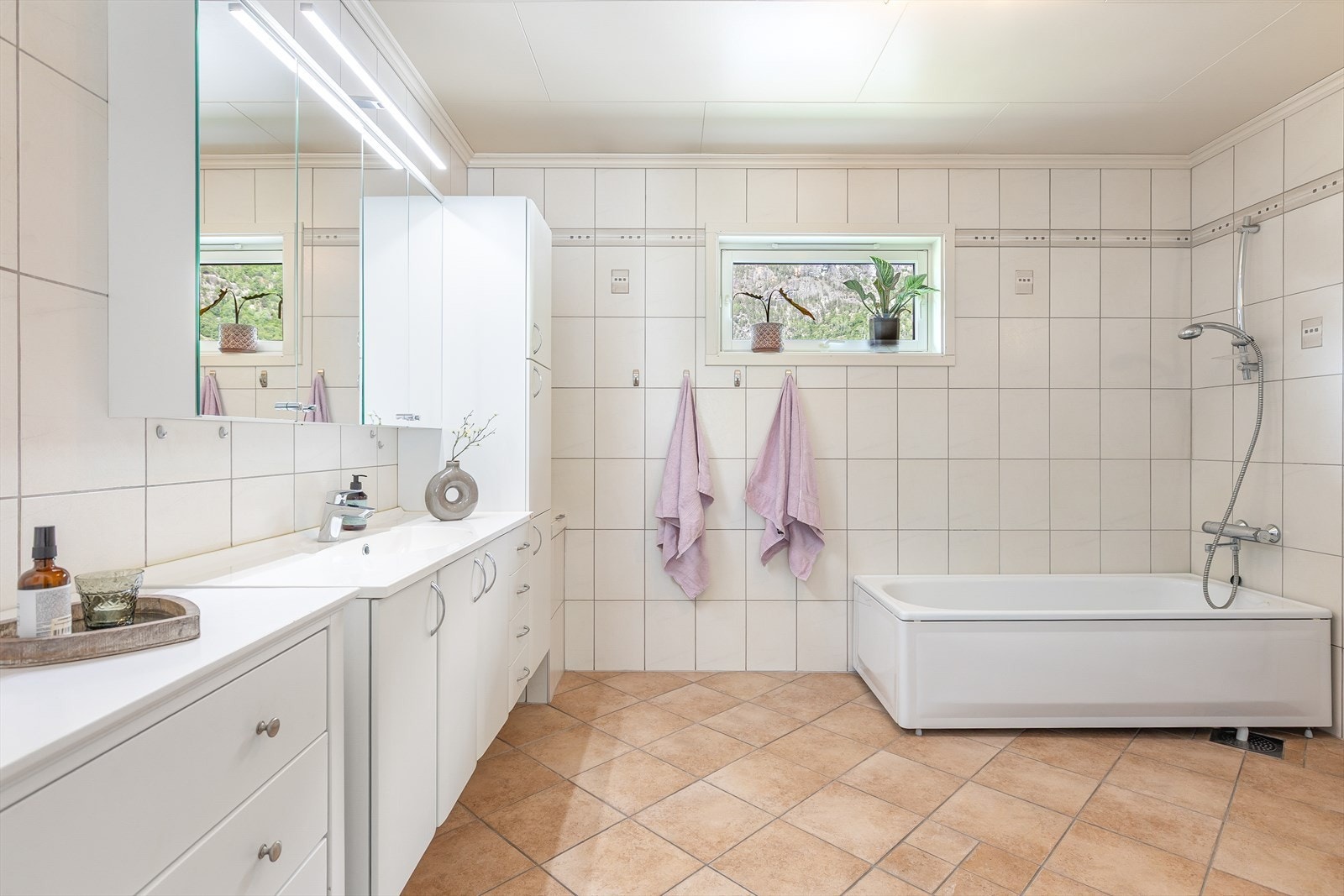 Badet har fliser på veggar, taket har himlingsplater og golvet er flislagt med elektriske varmekabler. Galleribilde