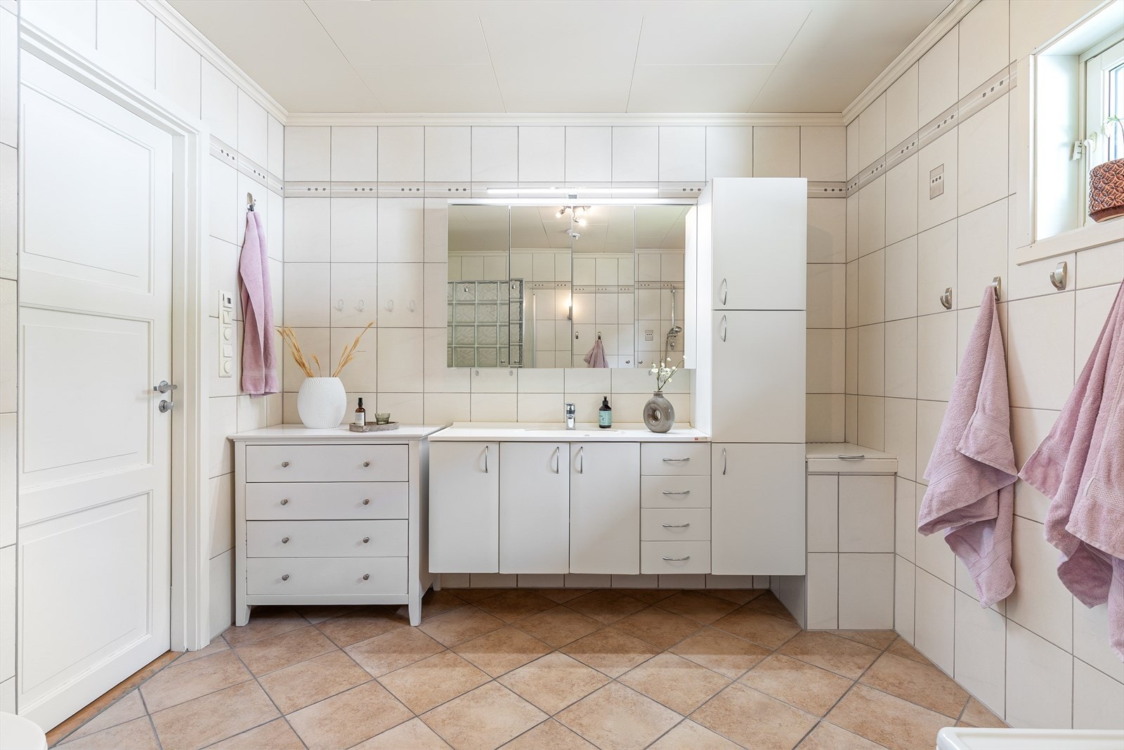 Rommet har innredning med nedfelt servant, veggmontert toalett, badekar og dusjvegger/hjørne. Galleribilde