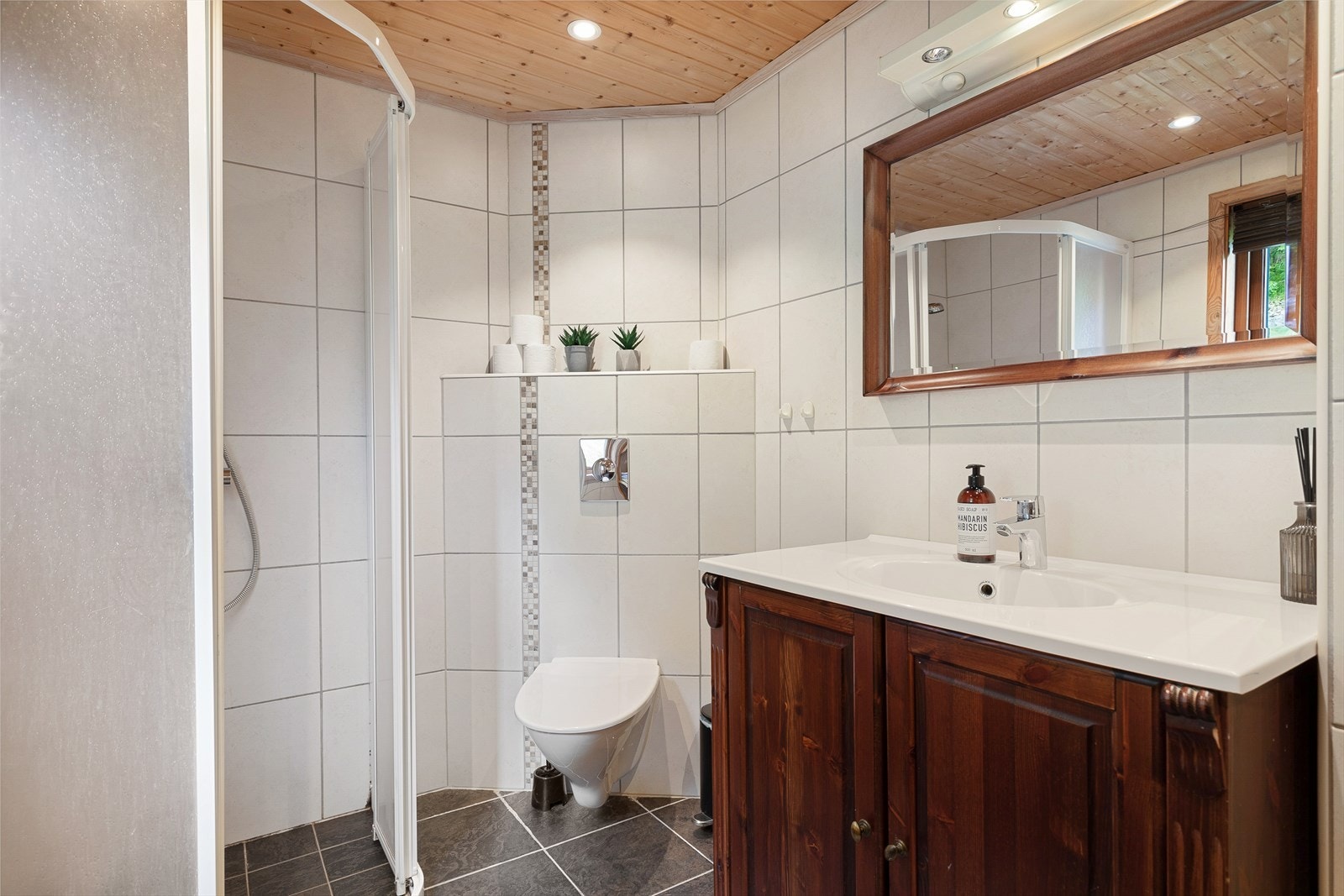 Baderommet inneheld dusj, toalett, servant med innreiing og opplegg for vaskemaskin. Galleribilde