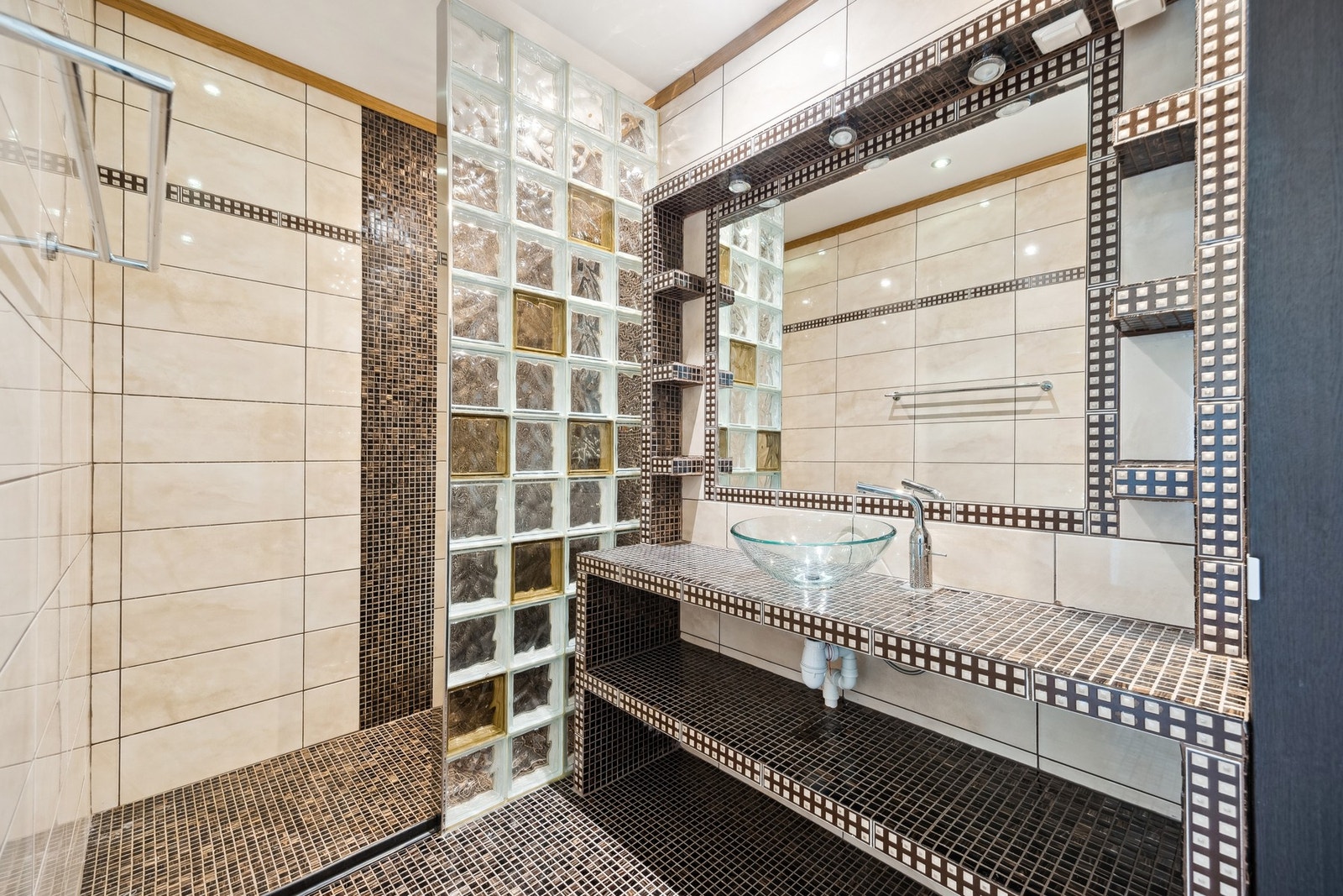 Flislagt bad med mørke fliser som gir rommet et lunt og rustikt preg, og romslig dusjhjørne med glassvegg. Galleribilde