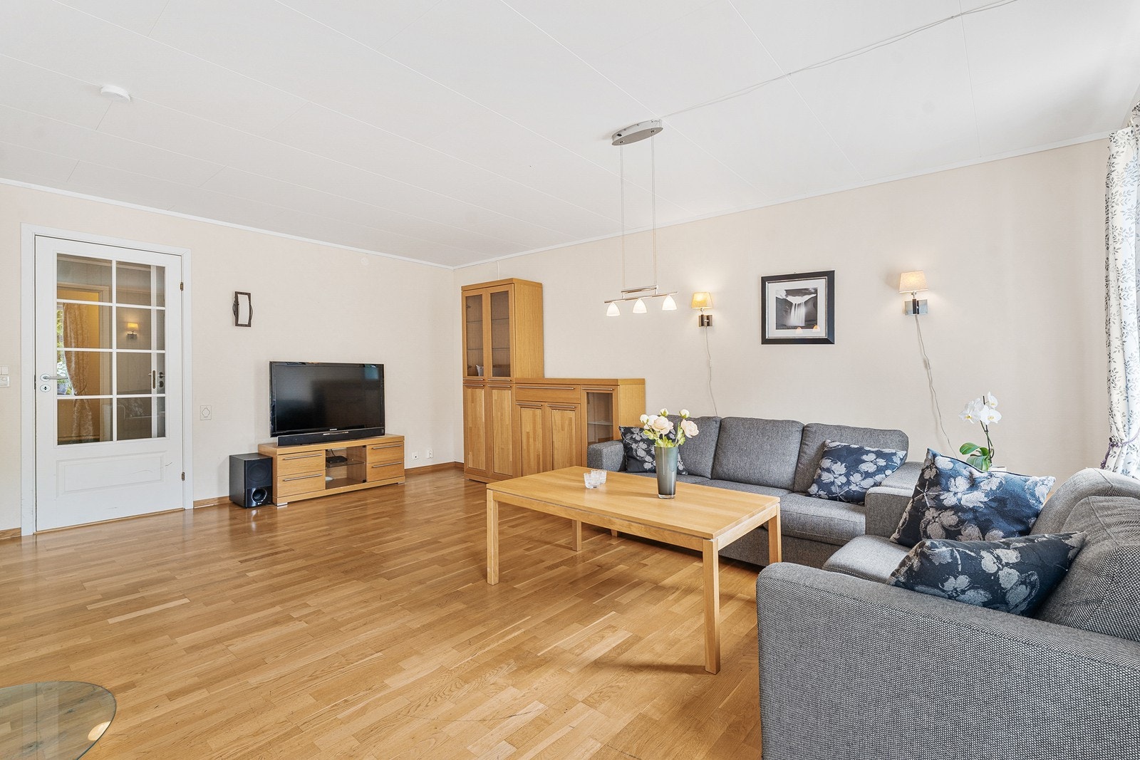 Leilighetens stue fremstår er stor og luftig, med god plass til en komfortabel sofagruppe, stuebord og tv-møblement. Galleribilde