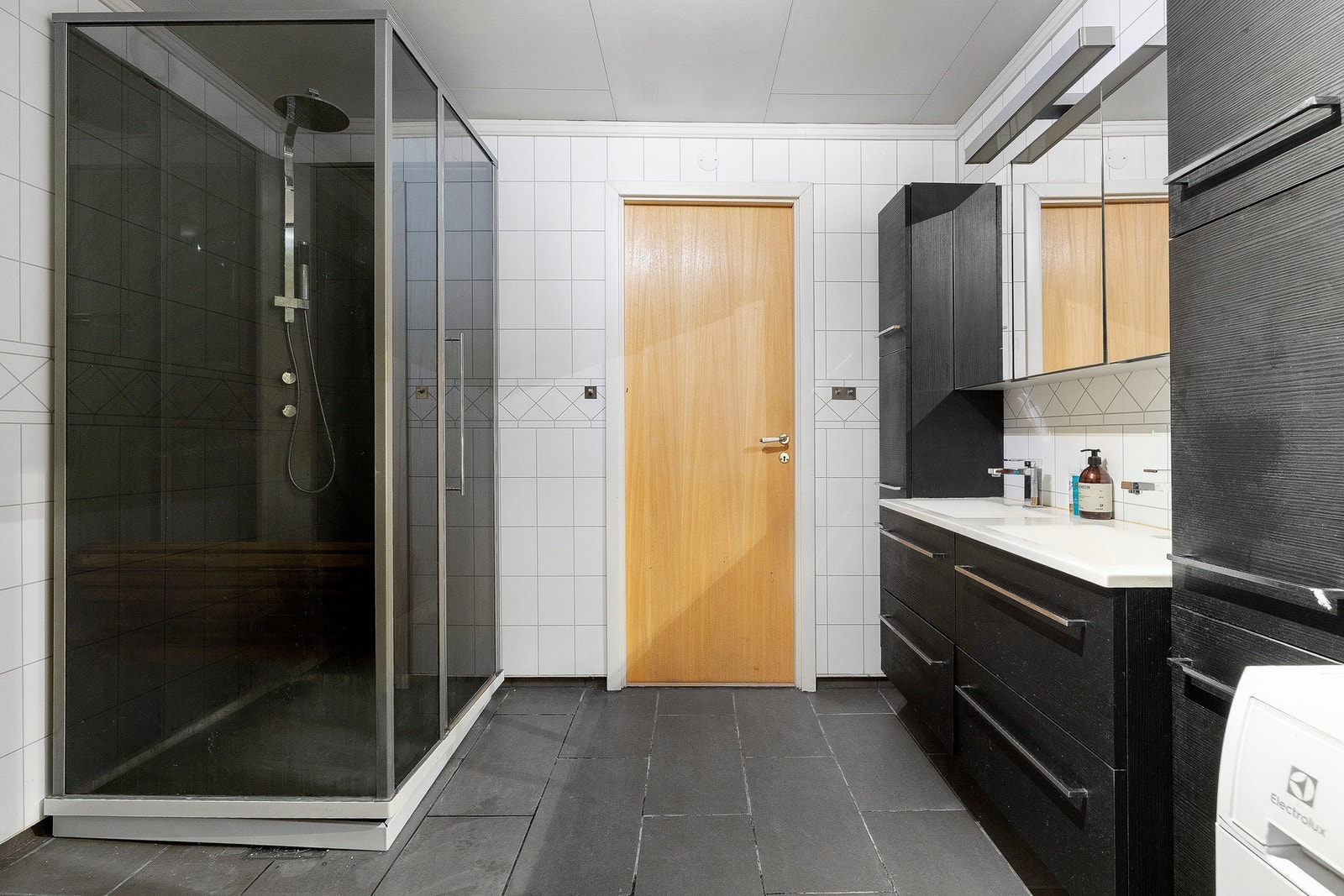 Badet er innredet med servant, speilskap, dusjsone og opplegg for vaskemaskin. Galleribilde