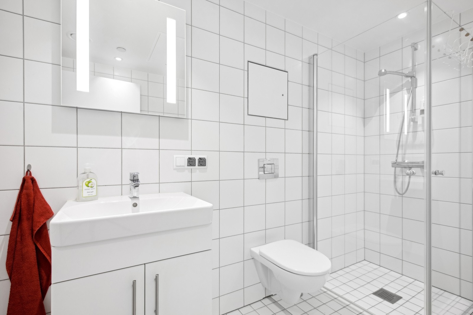 Badet byr på vegghengt toalett, dusjhjørne med innfellbare glassdører, servantinnredning med lagringsplass. Samt opplegg for vaskemaskin. Galleribilde