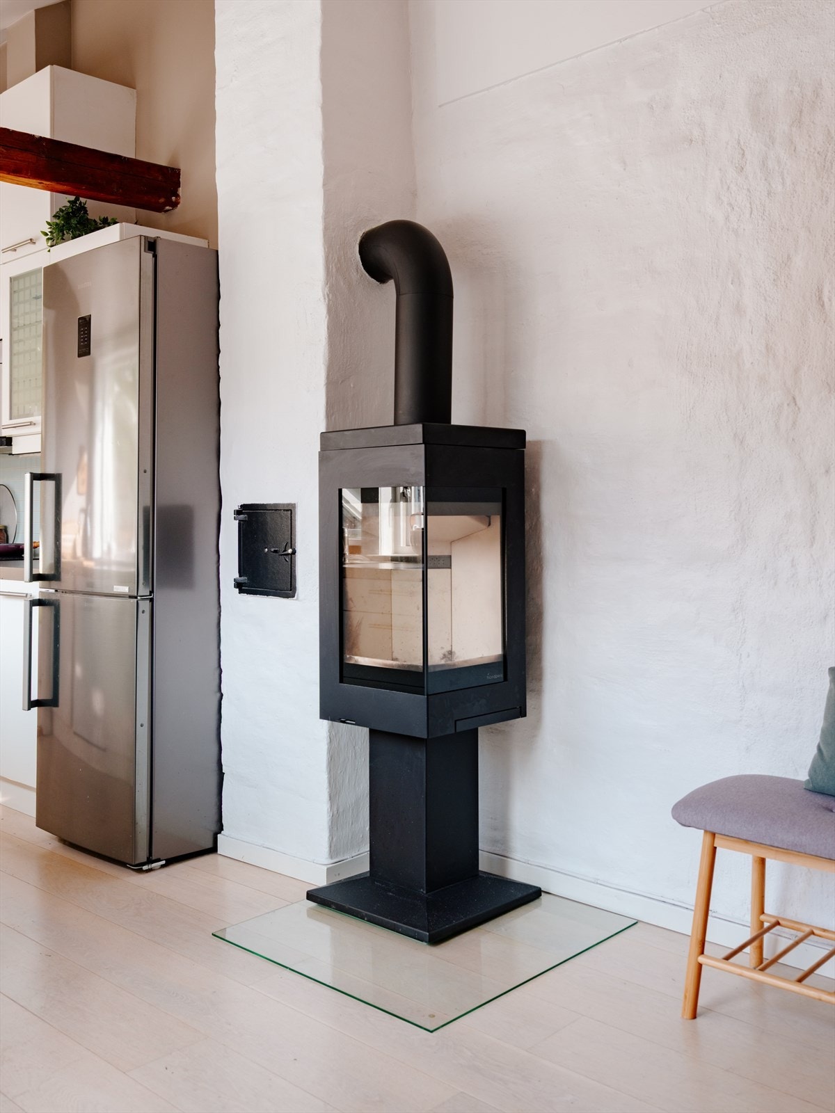 Midt i rommet er en stilfull vedovn som ikke bare gir ekstra varme, men også skaper en lun og koselig stemning Galleribilde