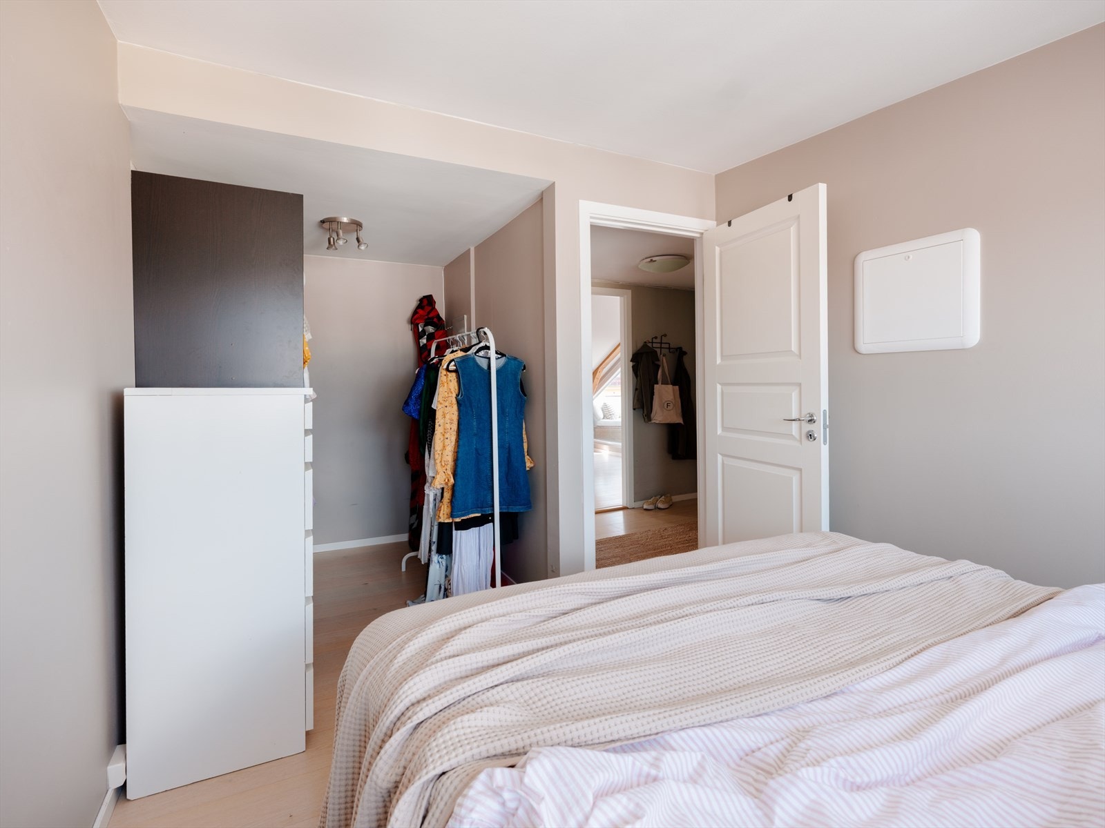 Rommet har plass til både dobbeltseng og garderobe, og den nøytrale stilen gjør det enkelt å tilpasse etter behov Galleribilde