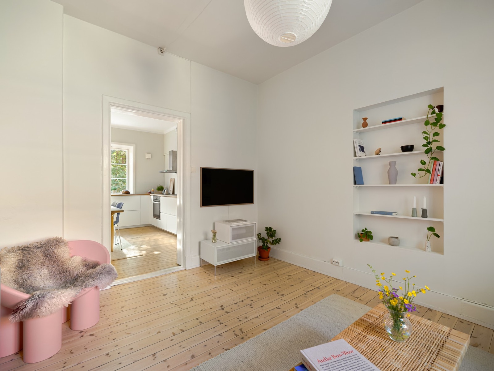 På den ene langveggen er det plassbygde hyller for ekstra lagring. Stuen kan også benyttes som et eget lukket rom, og original dør er bevart og følger med leilighet. Galleribilde