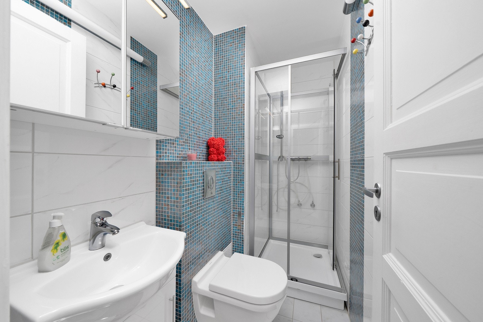 Badet har adkomst fra entré og fremstår som moderne med flislagte gulv og vegger. Belysningen består av veggmontert lampe, og det er elektriske varmekabler i gulvet for økt komfort. Overflateoppussing ble utført i 2018. Galleribilde