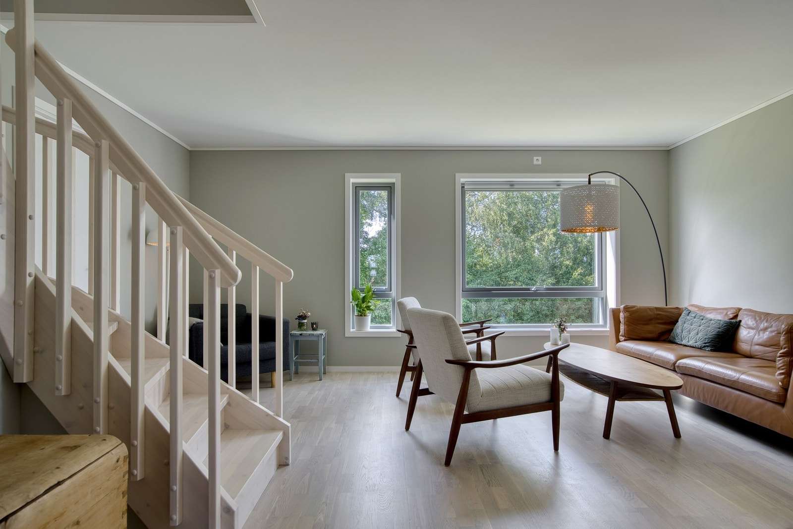 Stuen fremstår som et lyst og behagelig oppholdsrom med en gjennomført stil Galleribilde